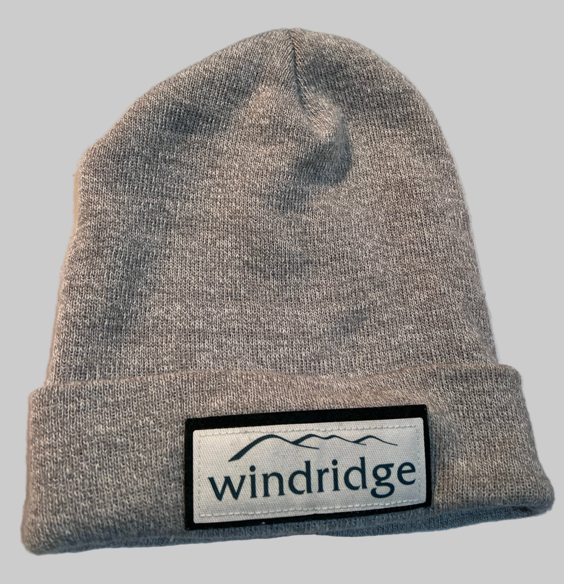 Light grey knitted acrylic wool winter beanie hat with 'windridge' logo patch on the front.